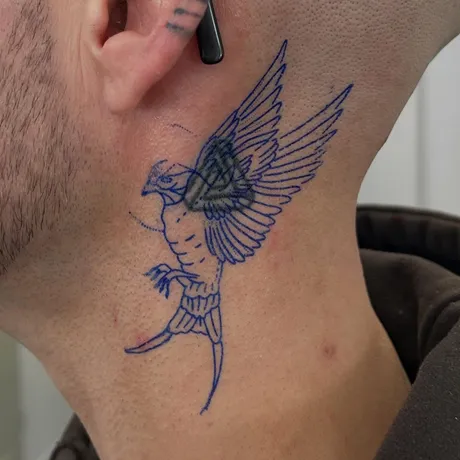 Stencil stage: A swallow over an old neck tattoo, with the old tattoo visible underneath